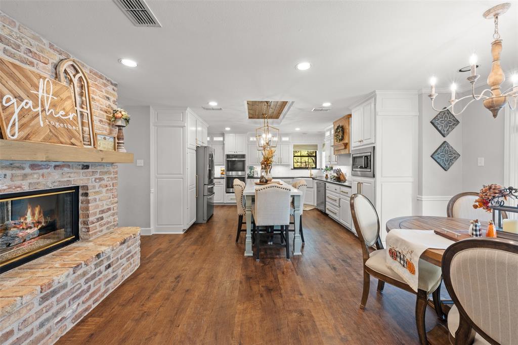 3050 Bosque Ridge Road Crawford, TX 76638 - Photo 16 of 40 a living room with furniture a fireplace and kitchen view