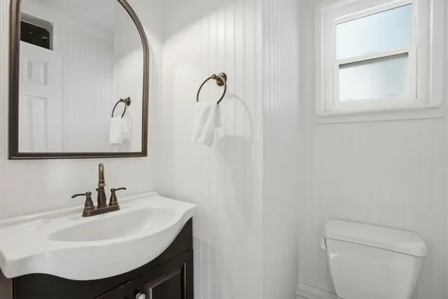 a bathroom with a sink toilet and mirror