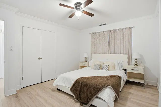a bedroom with a bed and a ceiling fan
