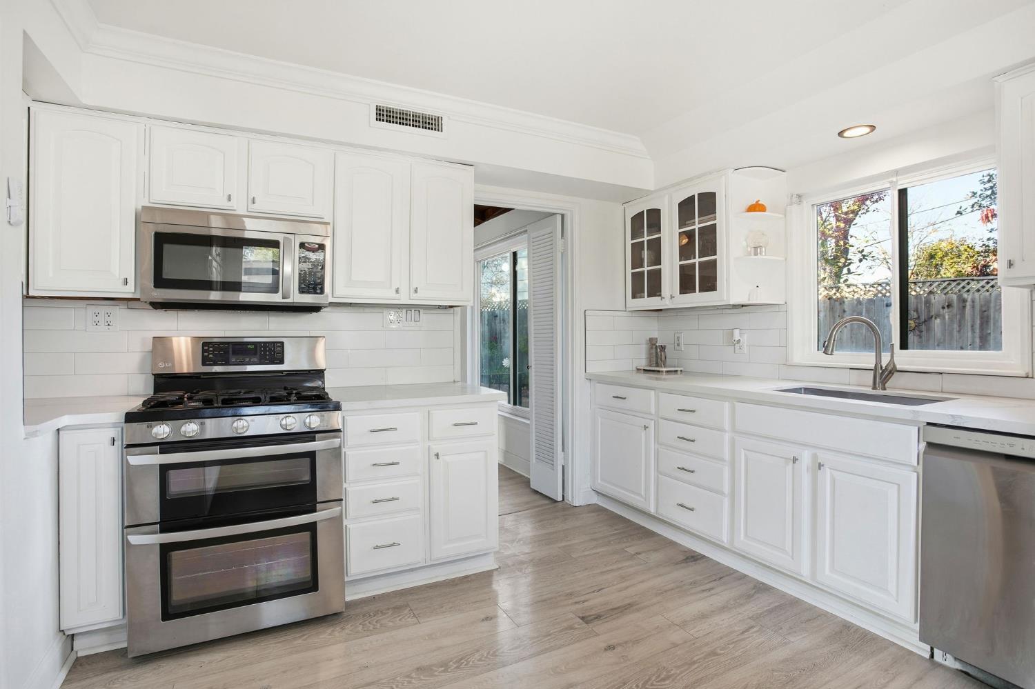 3801 Woodcrest Road Sacramento, CA 95821 - Photo 3 of 35 a kitchen with granite countertop cabinets stainless steel appliances and wooden floor