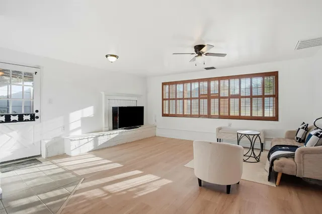 a living room with furniture fireplace and a window