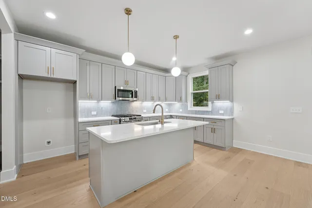 a kitchen with kitchen island a sink stainless steel appliances and cabinets