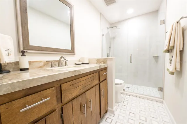 a spacious bathroom with a double vanity sink a mirror and a shower