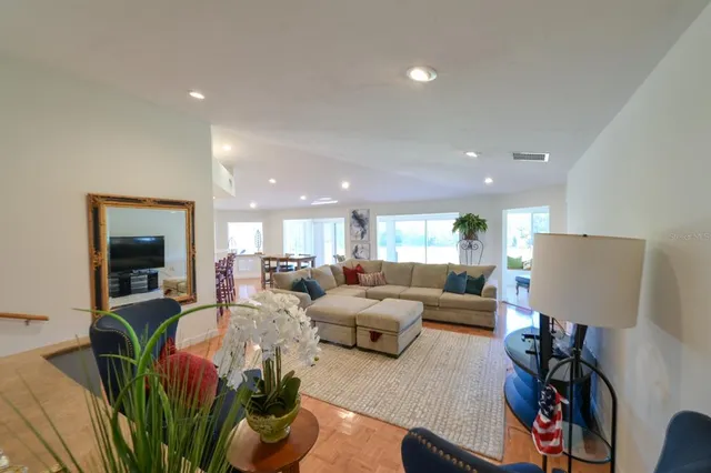 a living room with furniture potted plant and a flat screen tv