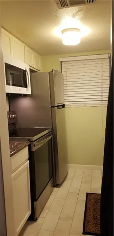 a kitchen with a refrigerator and cabinets