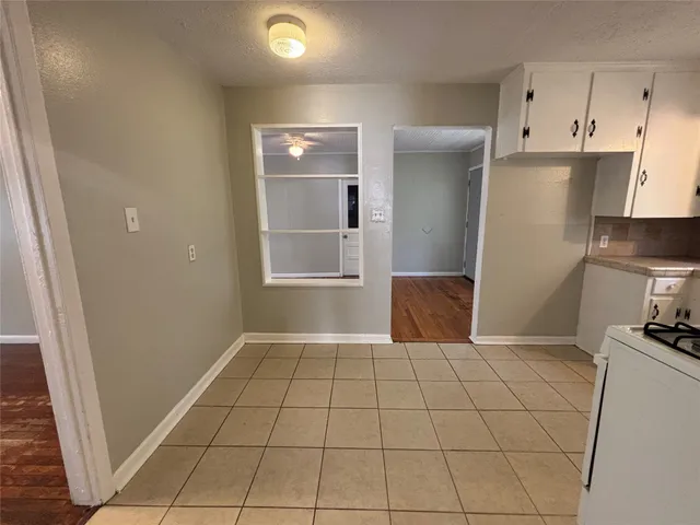 a kitchen with kitchen island granite countertop a refrigerator a sink a stove a microwave and cabinets