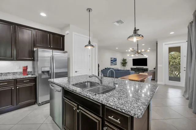 a kitchen with stainless steel appliances granite countertop a sink a stove and a refrigerator