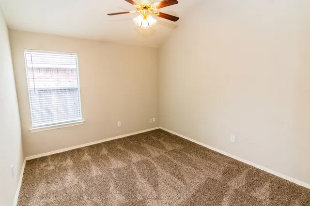 an empty room with a window and a fan