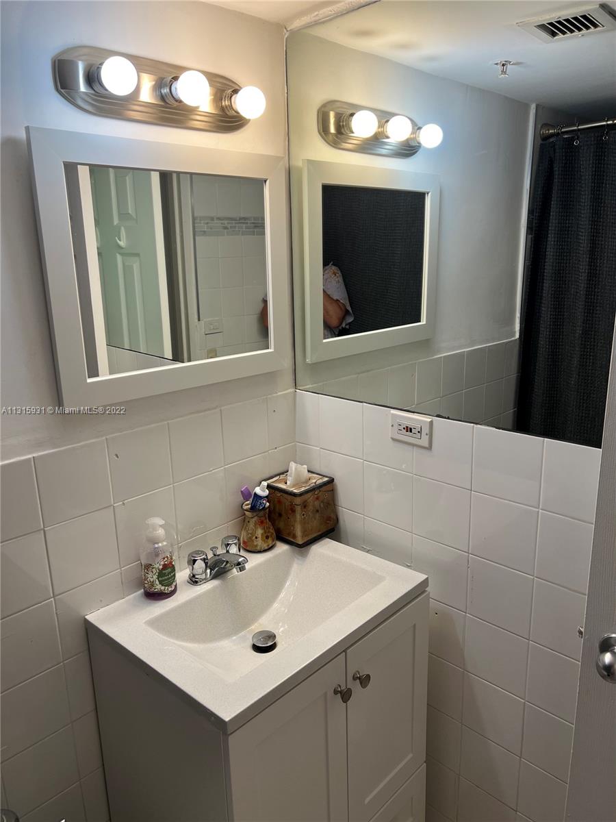 1500 Bay Road, Unit 944S Miami Beach, FL 33139 - Photo 28 of 82 a bathroom with a sink and a mirror