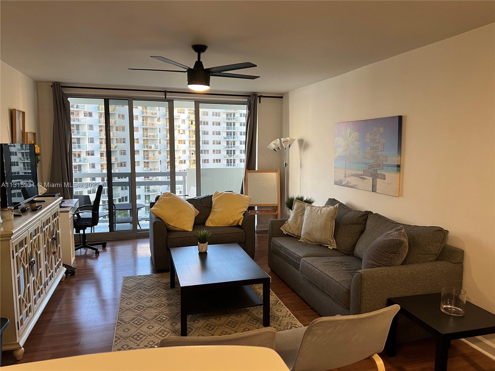 1500 Bay Road, Unit 944S Miami Beach, FL 33139 - Photo 9 of 82 a living room with furniture and a flat screen tv
