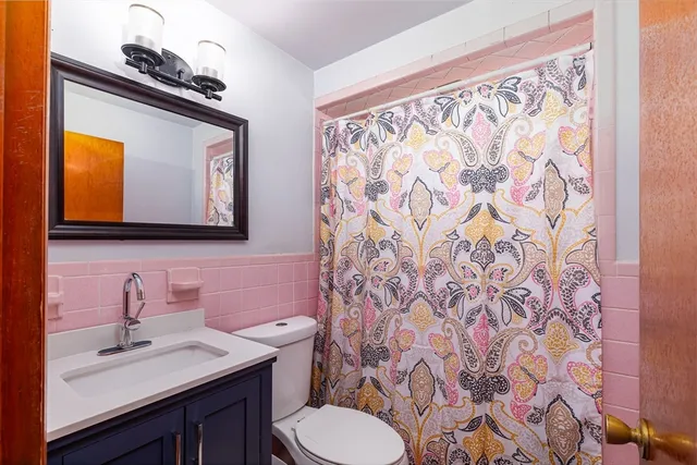 a bathroom with a sink toilet and mirror