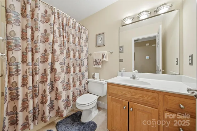 a bathroom with a granite countertop toilet sink and mirror