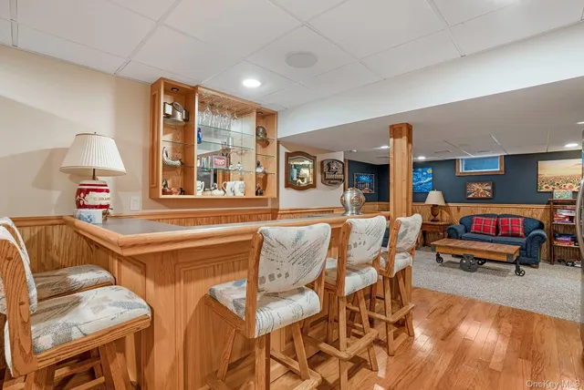 a living room with stainless steel appliances furniture and a kitchen view