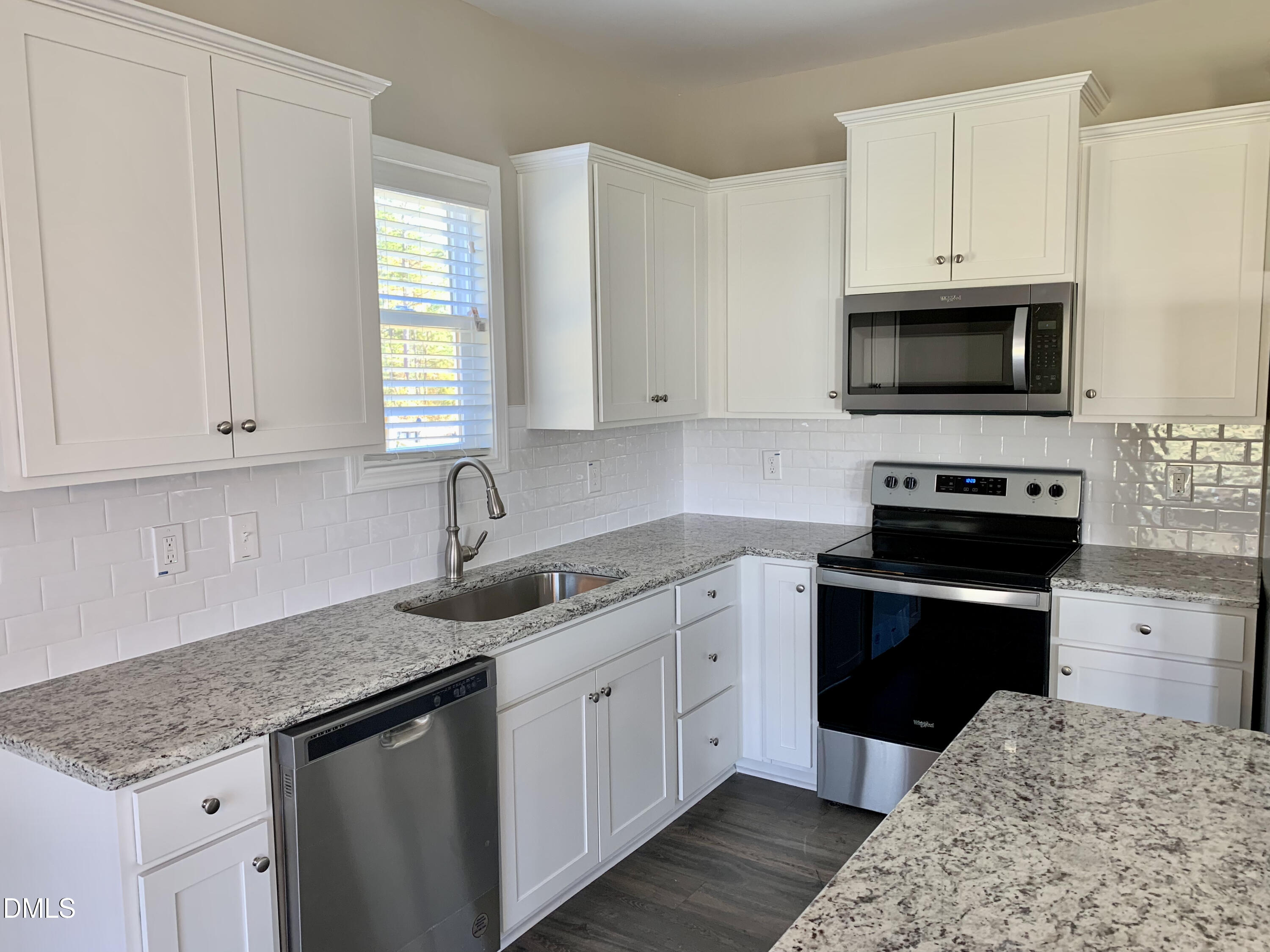 48 Weathervane Dr. Zebulon, NC 27597 - Photo 4 of 24 a kitchen with granite countertop white cabinets and stainless steel appliances