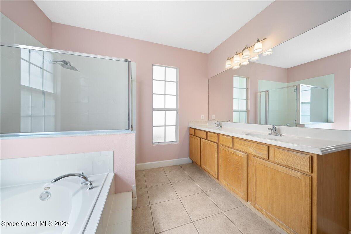320 Pebble Hill Way Rockledge, FL 32955 - Photo 14 of 27 a spacious bathroom with a granite countertop sink a mirror a bathtub and window