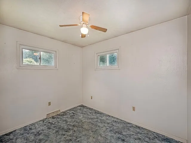 a view of a room with a chandelier fan