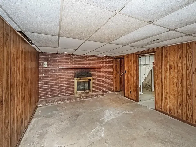 a view of an empty room with a fireplace and a window