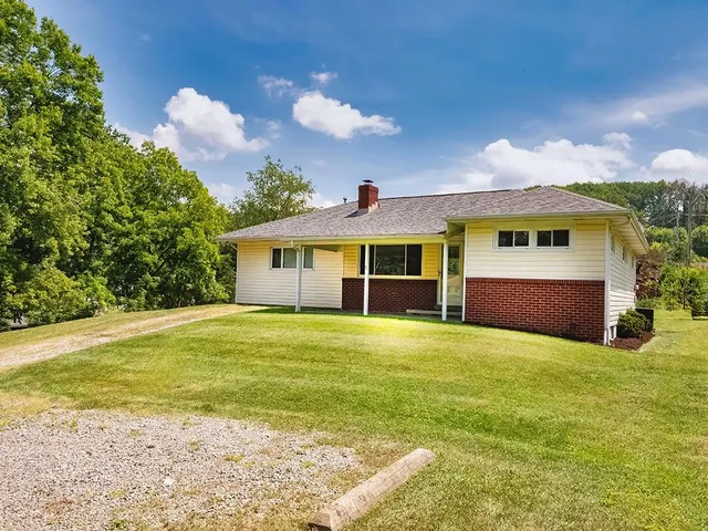 a front view of a house with a garden and yard