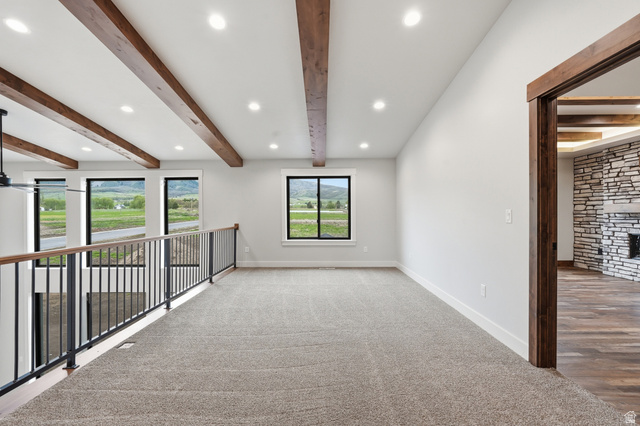 2970 North Mahogany Vly Road Logan, UT 84341 - Photo 19 of 39 Carpeted spare room with beamed ceiling, recessed lighting, and a fireplace