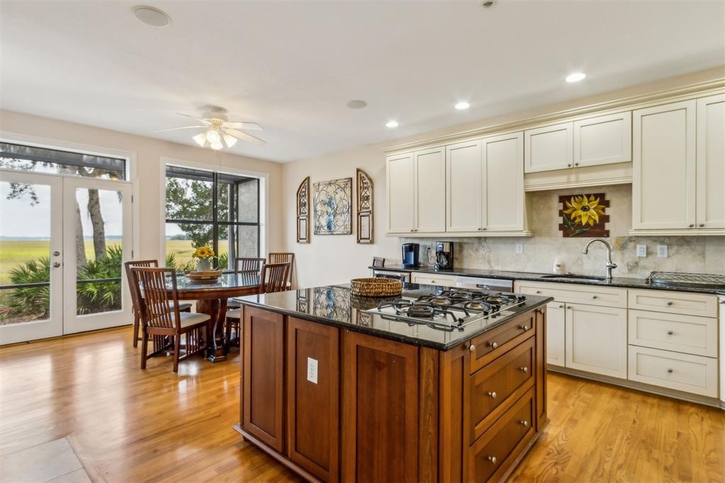 3119 Sea Marsh Road Fernandina Beach, FL 32034 - Photo 5 of 41 a kitchen with stainless steel appliances granite countertop a stove top oven a sink dishwasher a dining table and chairs with wooden floor
