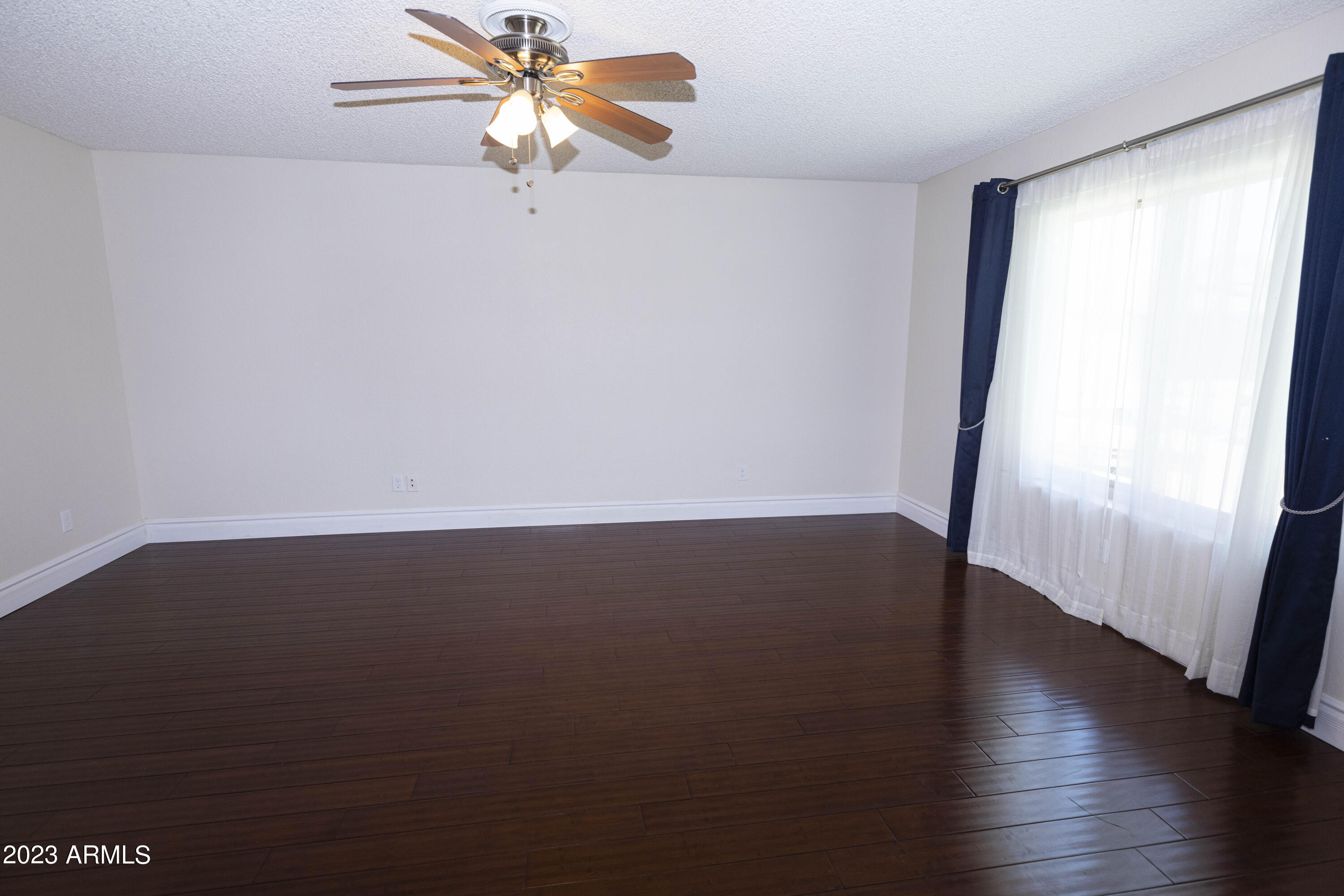608 East Appaloosa Road Gilbert, AZ 85296 - Photo 12 of 38 an empty room with wooden floor and fan