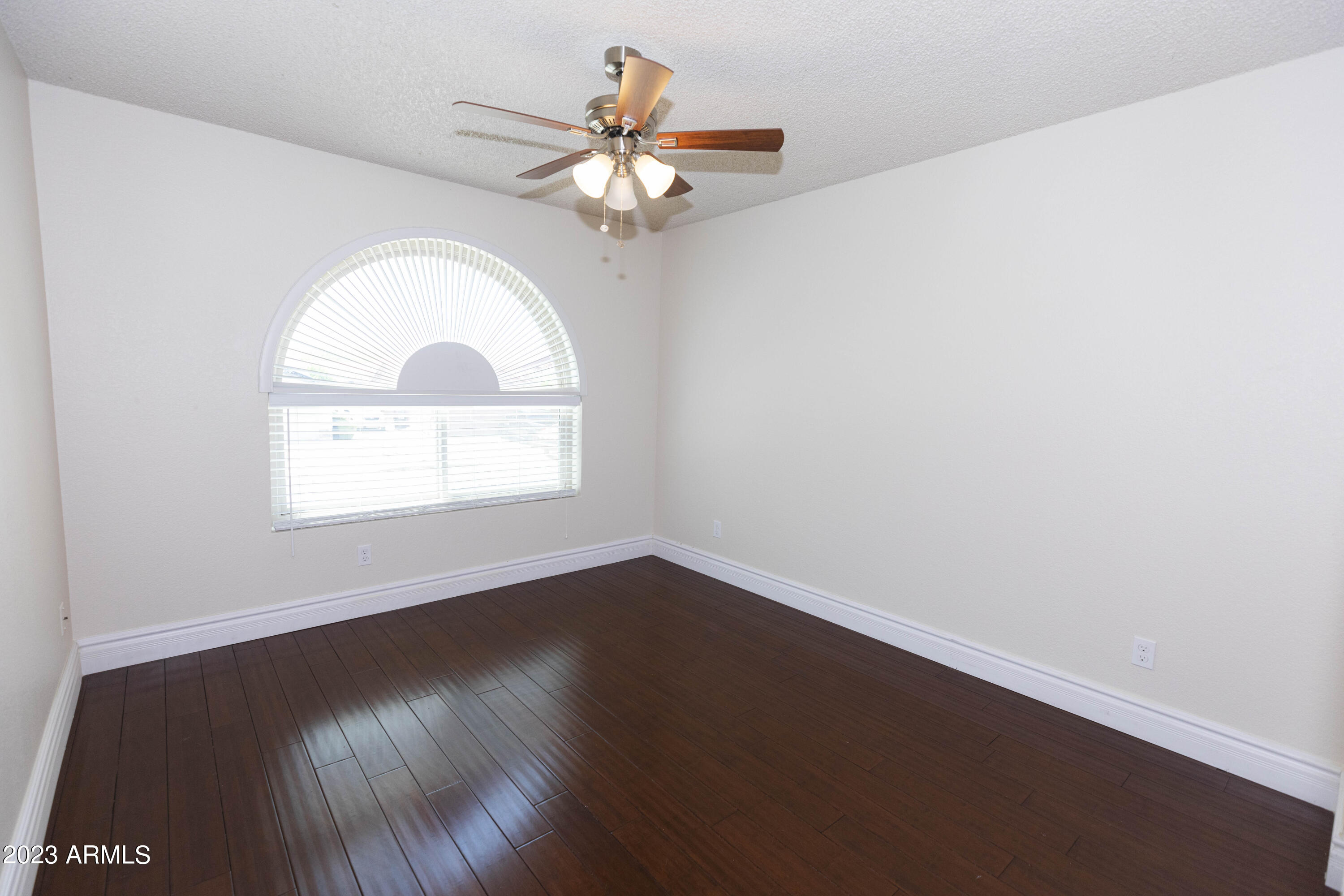 608 East Appaloosa Road Gilbert, AZ 85296 - Photo 18 of 38 an empty room with wooden floor chandelier fan and window