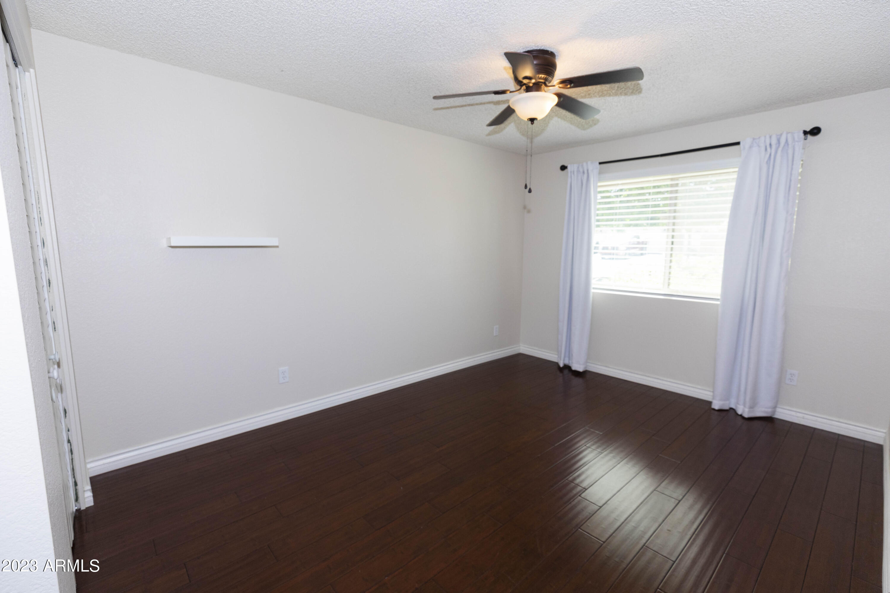 608 East Appaloosa Road Gilbert, AZ 85296 - Photo 20 of 38 an empty room with wooden floor chandelier fan and windows
