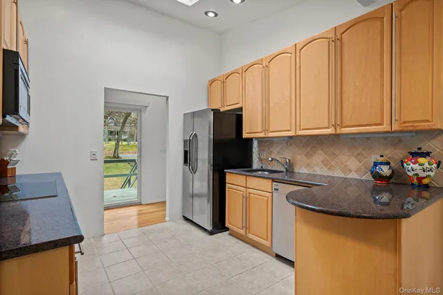 a kitchen with stainless steel appliances granite countertop a refrigerator sink and stove