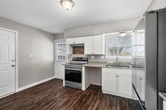 a kitchen with stainless steel appliances granite countertop a stove a sink and a refrigerator