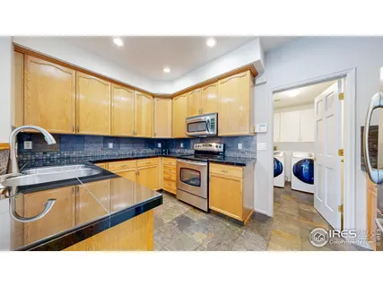 a kitchen with a sink a stove and cabinets