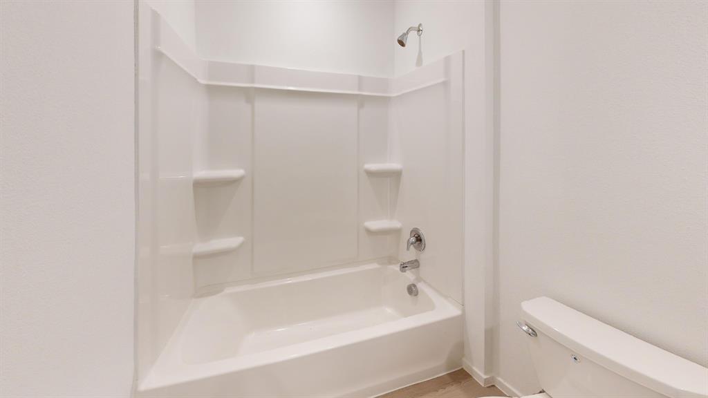 1005 Calley Pear Trail Princeton, TX 75407 - Photo 16 of 20 a bathroom with a bathtub and a toilet