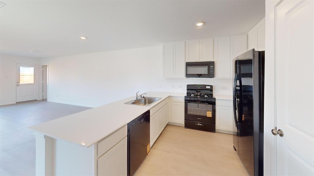 1005 Calley Pear Trail Princeton, TX 75407 - Photo 4 of 20 a kitchen with a refrigerator and a stove top oven