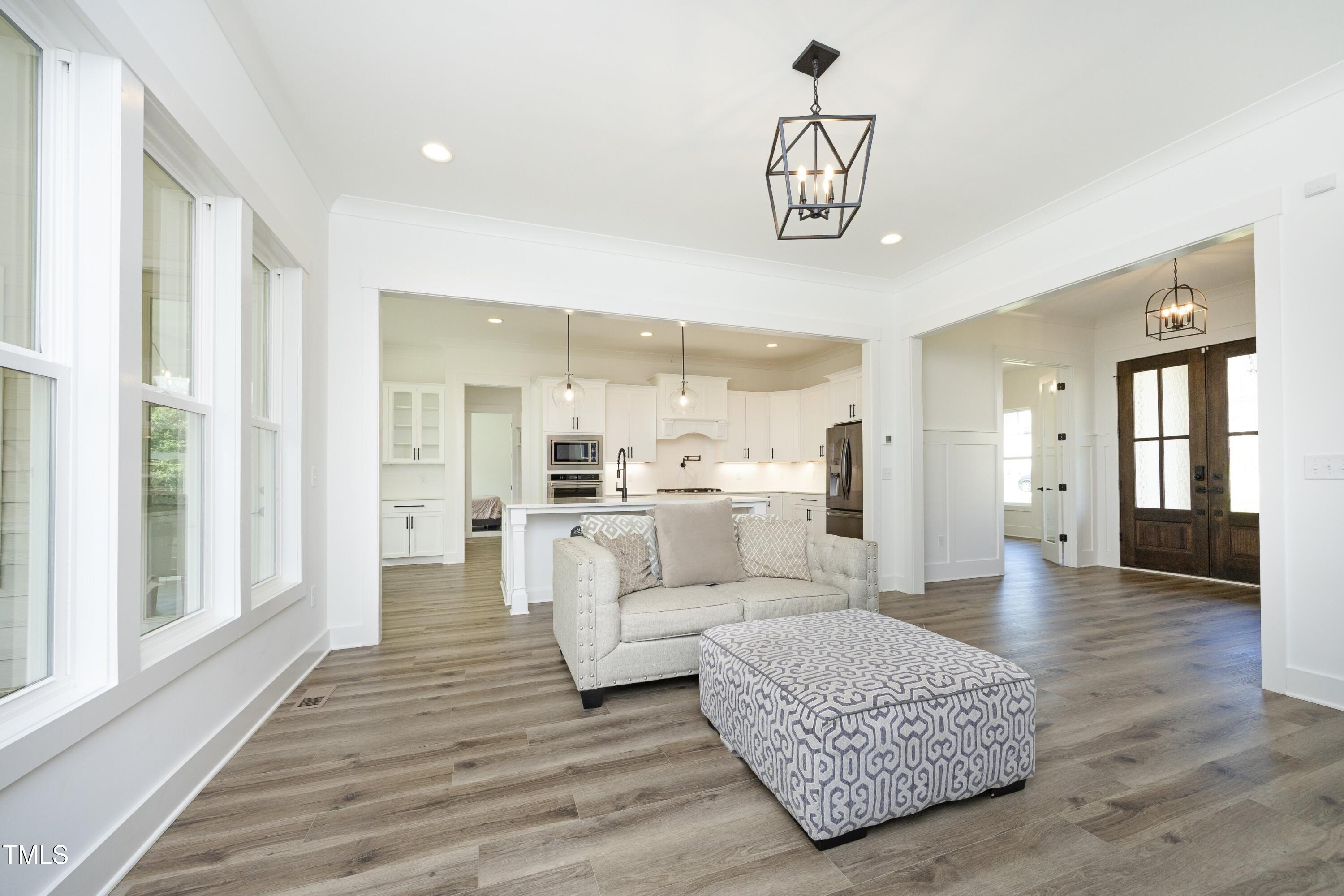1145 Duke Farm Drive Wake Forest, NC 27587 - Photo 10 of 37 a living room with furniture and a chandelier