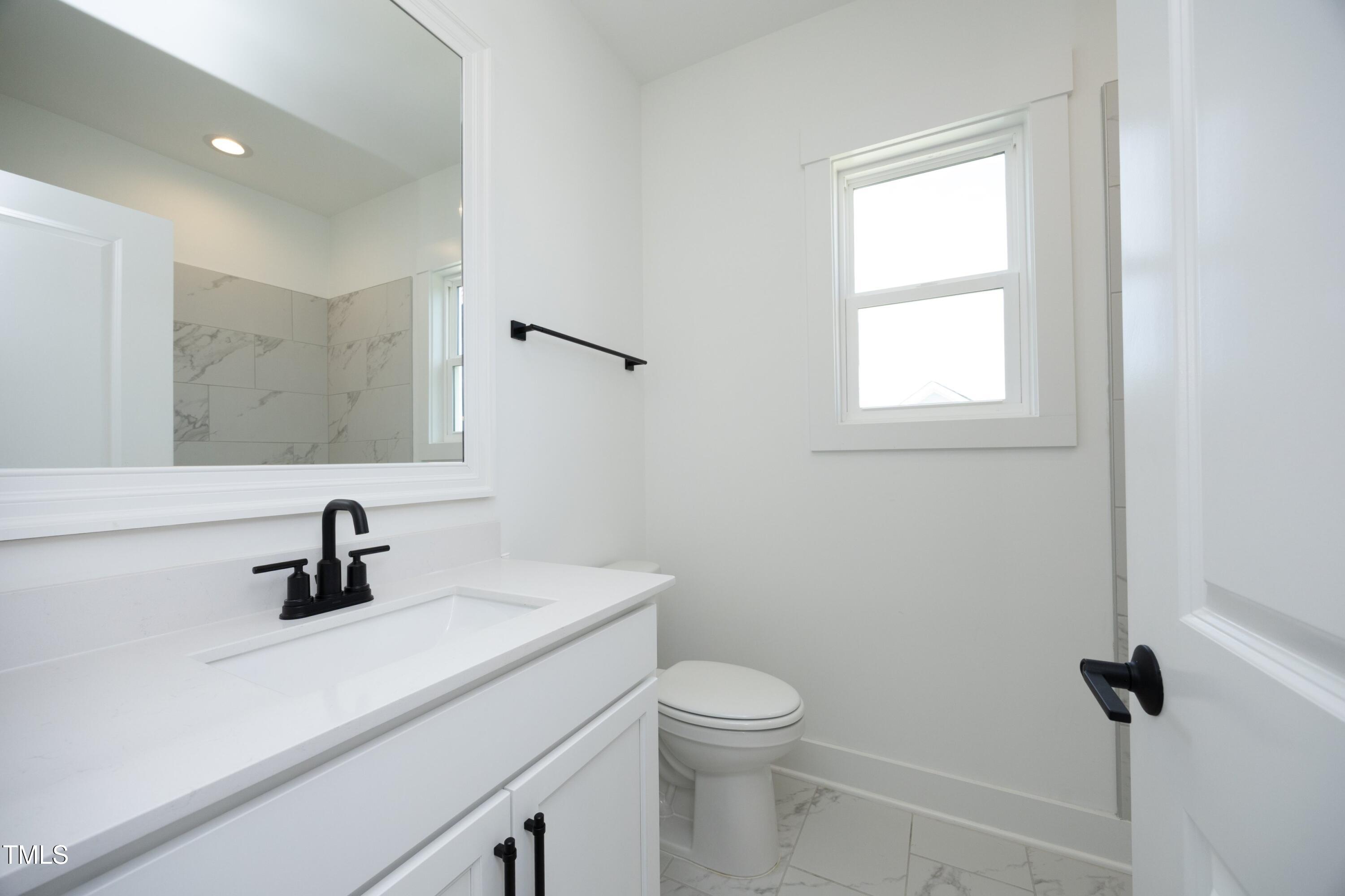 1145 Duke Farm Drive Wake Forest, NC 27587 - Photo 22 of 37 a bathroom with a sink a toilet and a window