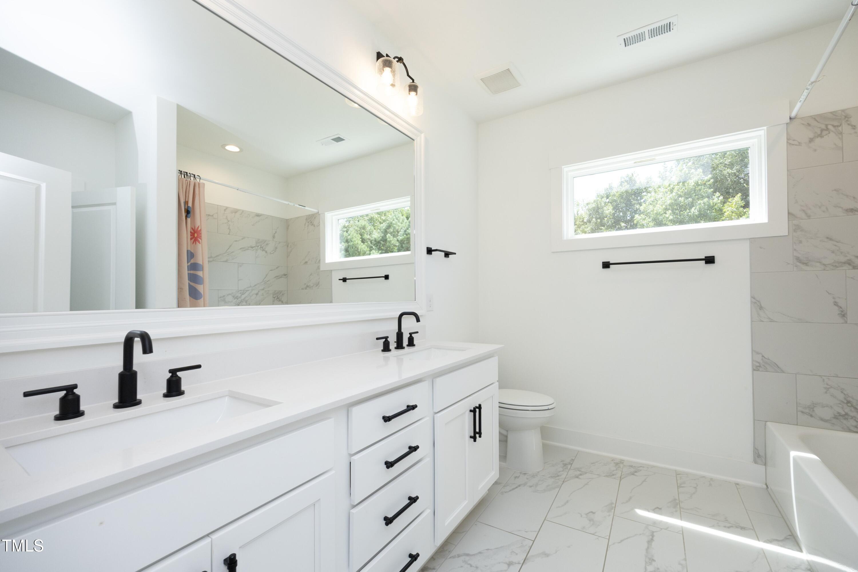 1145 Duke Farm Drive Wake Forest, NC 27587 - Photo 28 of 37 a bathroom with a double vanity sink toilet and a mirror