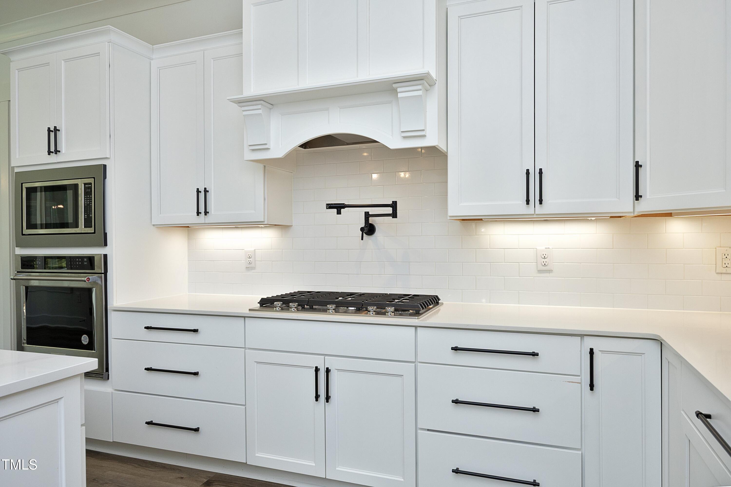 1145 Duke Farm Drive Wake Forest, NC 27587 - Photo 7 of 37 a kitchen with white cabinets and a stove with a sink