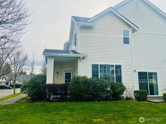 a front view of a house with a garden and yard