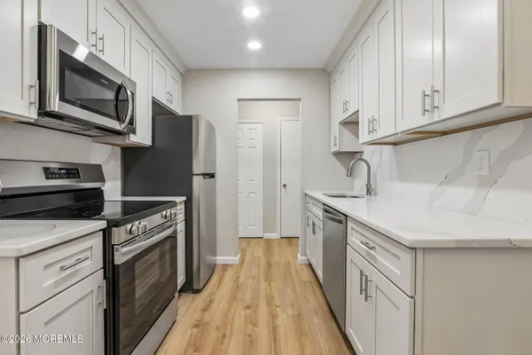 a kitchen with stainless steel appliances granite countertop a kitchen island hardwood floor sink and stove