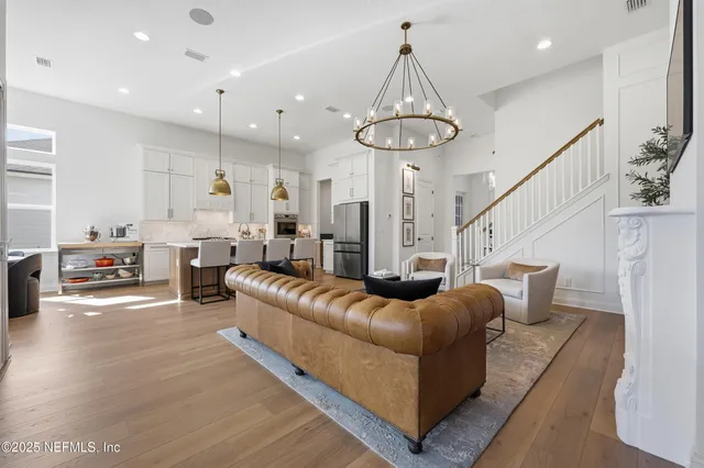 a dining room with wooden floor a chandelier a wooden table and chairs