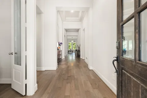 a view of a hallway with wooden floor and staircase