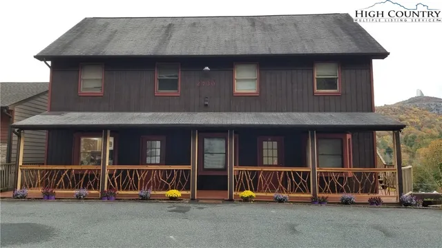 a view of a brick house with large windows and a table and chairs