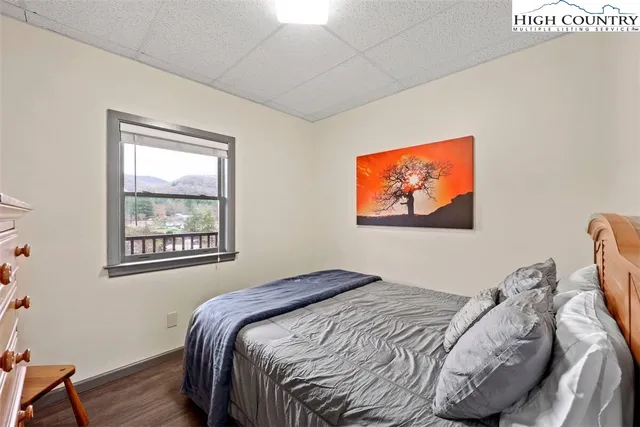 a bedroom with bed and wall painting with wooden floor