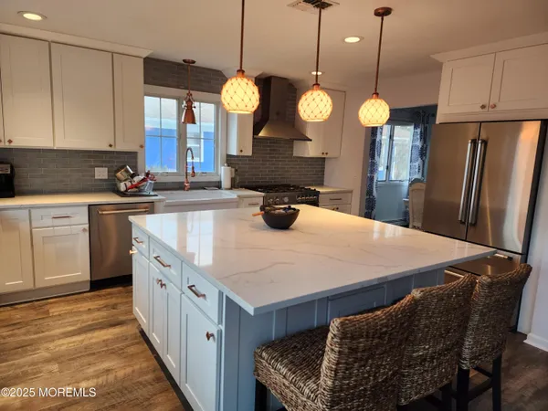 a kitchen with granite countertop a stove oven and white cabinets