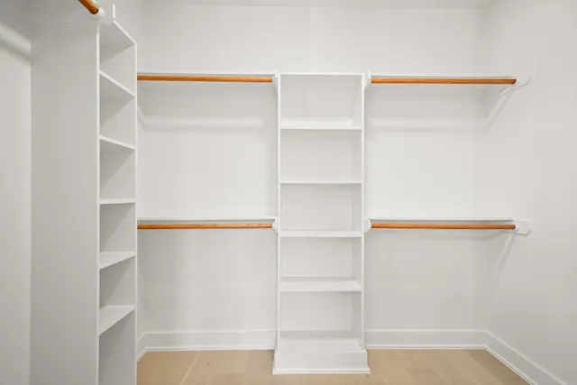 a view of walk in closet with empty racks