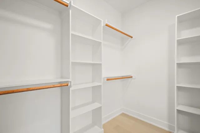 a view of walk in closet with empty racks
