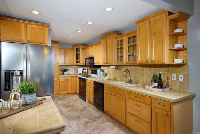 a kitchen with stainless steel appliances a stove a sink a microwave and cabinets