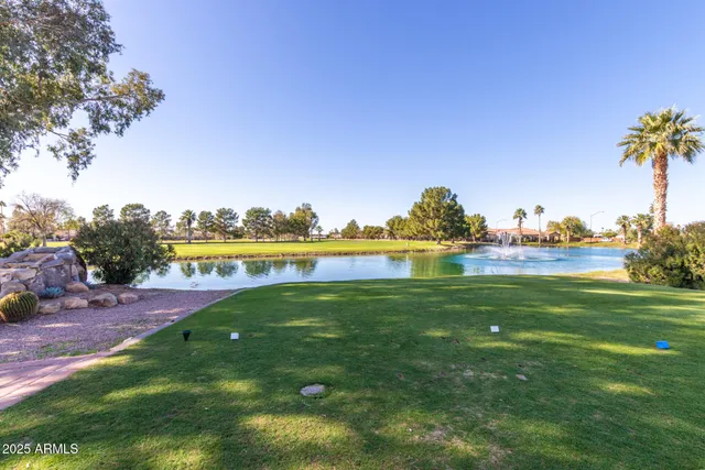 a view of a fountain in front of a house with a big yard