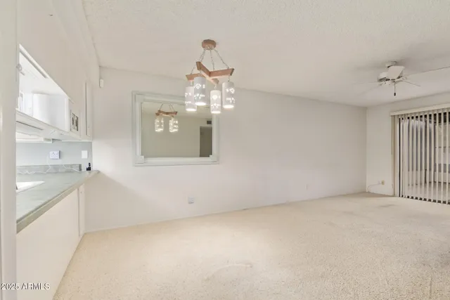 a room with kitchen island a chandelier and wooden floor