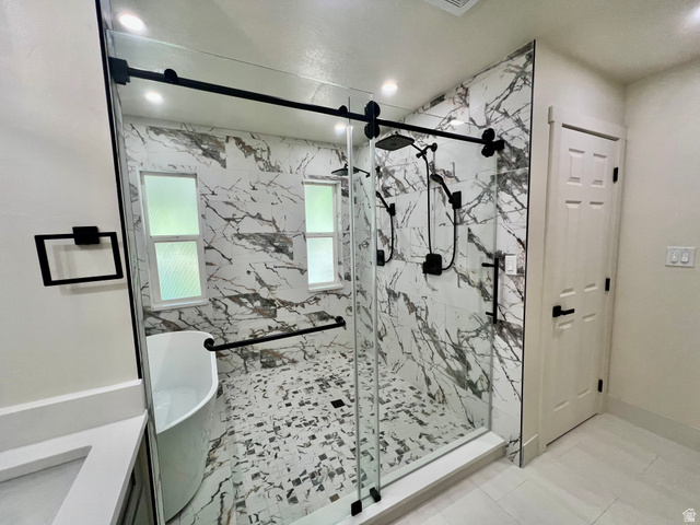 812 East Bates Cyn Road Tooele, UT 84074 - Photo 44 of 144 Spacious bathroom featuring a frameless glass shower enclosure with matte black hardware, a freestanding soaking tub, and floor-to-ceiling marble-look tile