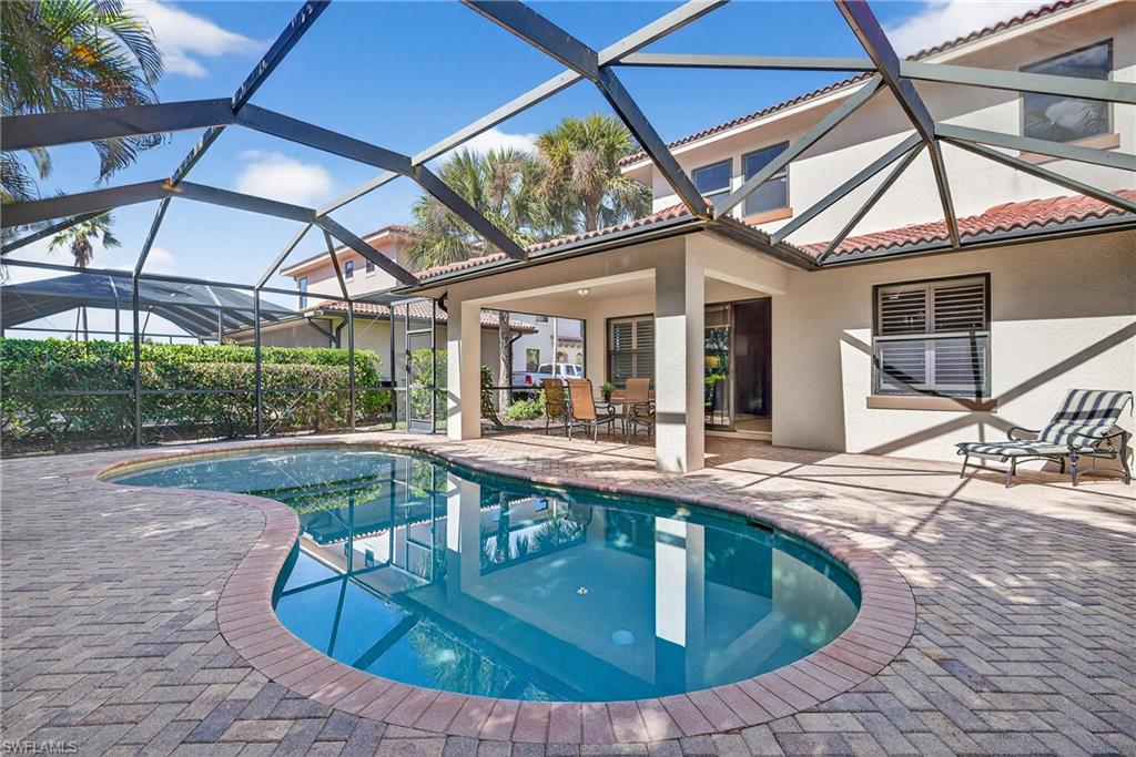 Swimming pool featuring a sunshelf, screened lanai, and paver patio.